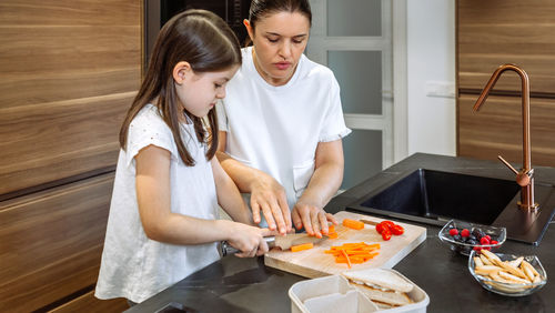 Woman holding food while standing at home