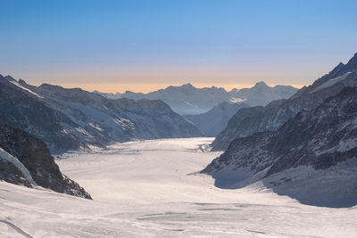 Scenic view of snowcapped mountains against clear sky during winter