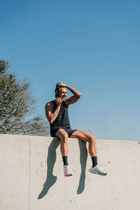 Full length of man on beach against clear blue sky