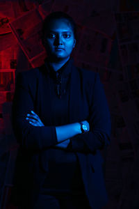 Portrait of young man standing against wall