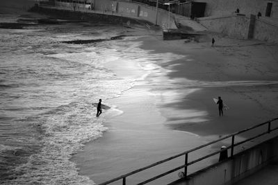 High angle view of people with surfboard at sea shore