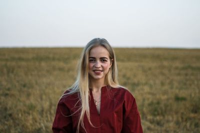 Portrait of smiling young woman standing on land