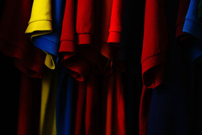Colorful clothes hanging against black background