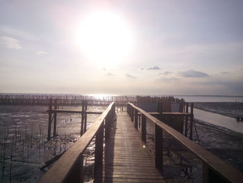 Pier over sea against sky during sunset