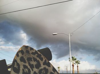 Low angle view of power lines against cloudy sky