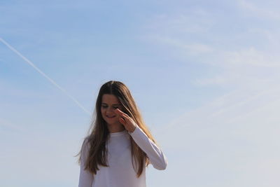 Portrait of woman standing against sky