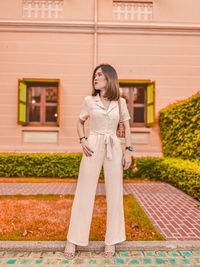 Portrait of woman standing against building