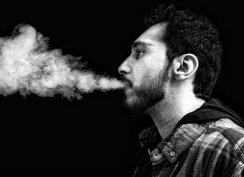 Portrait of young man against black background