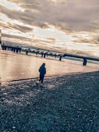 People on beach against sky during sunset