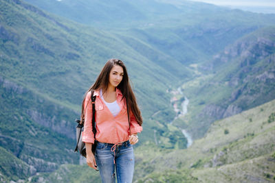 Portrait of young woman standing on mountain