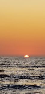 Scenic view of sea against orange sky