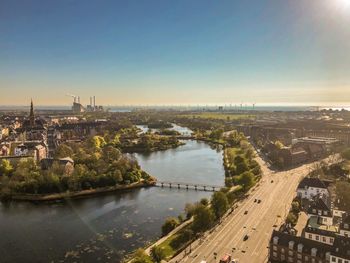 High angle view of cityscape by river against sky