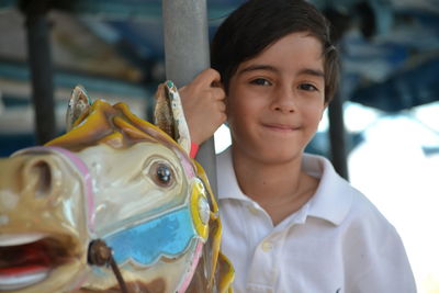 Portrait of smiling boy on carousel horses