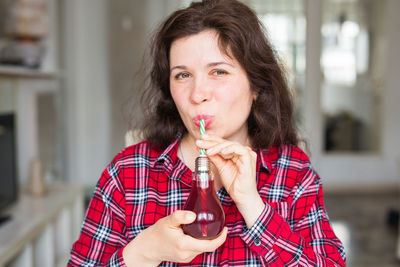 Woman drinking juice at home