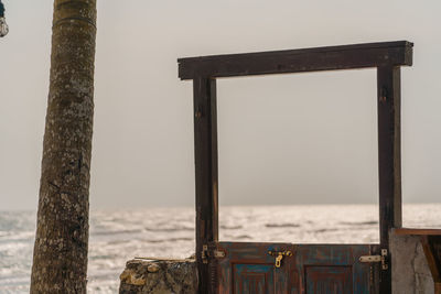 Wooden posts on beach against clear sky