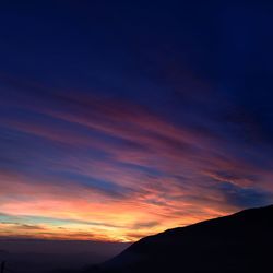 Low angle view of silhouette mountain against romantic sky