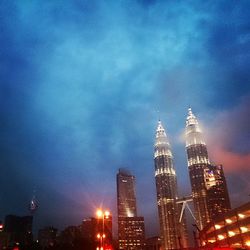 Low angle view of illuminated cityscape against sky at night