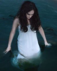 Young woman standing in sea