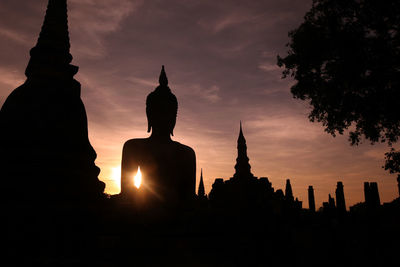 Silhouette of statue of building at sunset