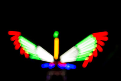 Close-up of illuminated multi colored lights against black background