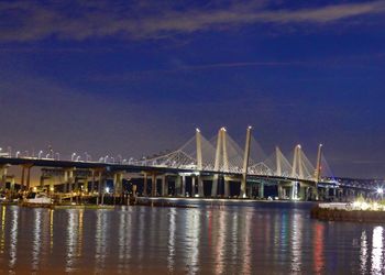 View of bridge over river at night