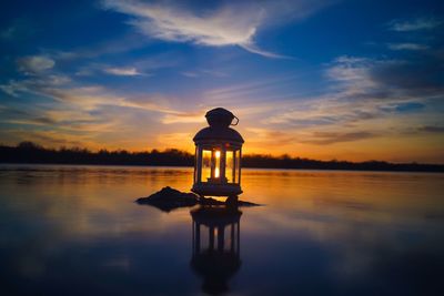 Lifeguard hut in lake during sunset