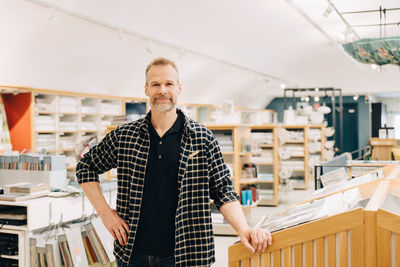 Portrait of smiling salesman standing in store