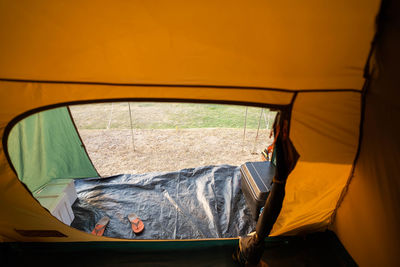 View from inside the tent with camping gear and floor slippers.