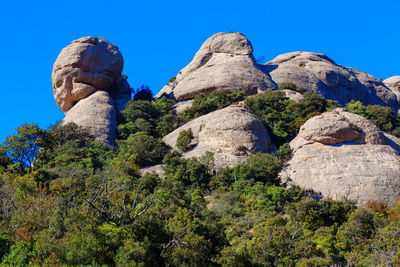 Low angle view of rocks against blue sky