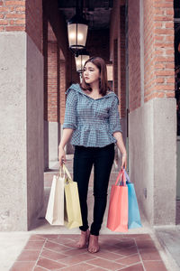 Full length of young woman holding umbrella