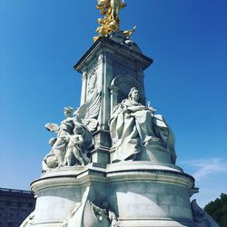 Low angle view of statue against blue sky