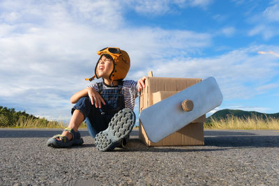 Low angle view of woman sitting on road