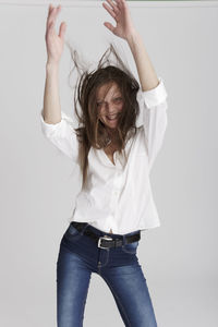 Portrait of smiling girl standing against white background
