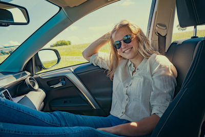 Portrait of young woman sitting in car