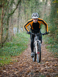 Full length of man cycling in forest