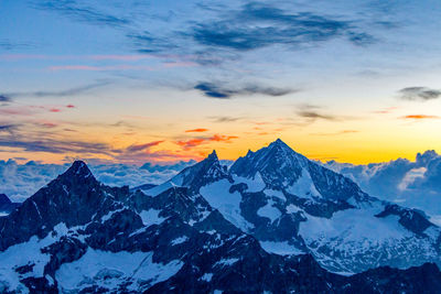 Scenic view of snowcapped mountains against sky during sunset