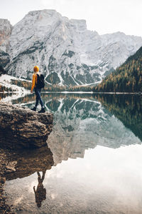 Full length of man standing by lake against mountain