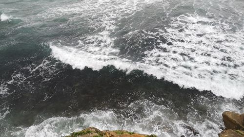 High angle view of waves splashing on sea