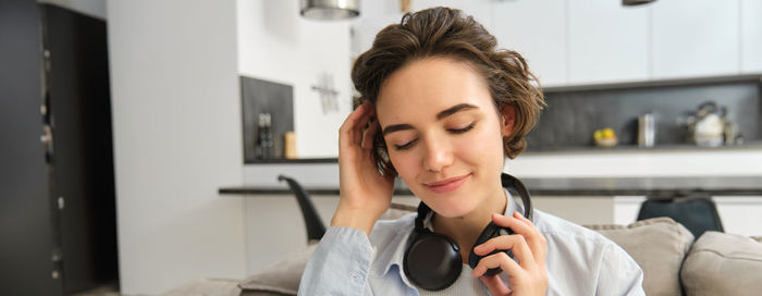 Young woman using mobile phone at home