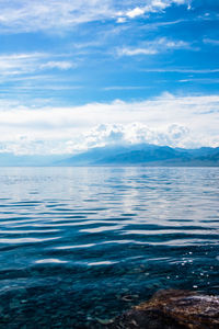 Low angle view of lake against cloudy sky