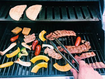 High angle view of man cooking on barbecue grill