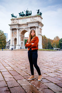 Portrait of beautiful young woman against monument