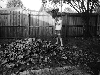 Full length of woman standing on wooden fence