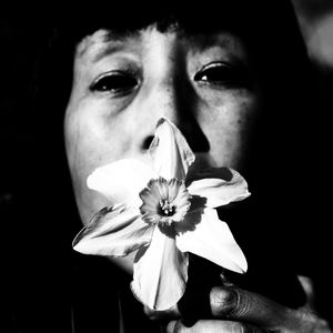 Close-up portrait of woman against black background