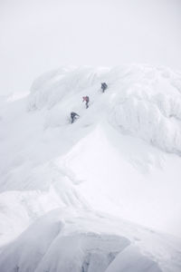 People skiing on snow covered landscape