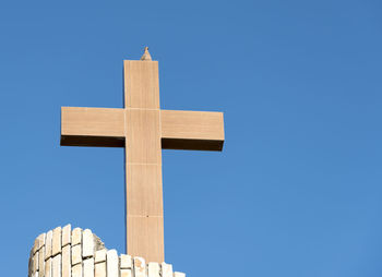 Low angle view of cross against clear blue sky