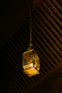 Low angle view of illuminated chandelier hanging on ceiling