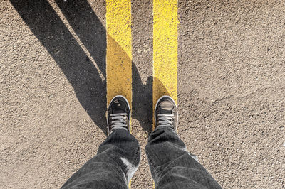 Low section of man standing on road