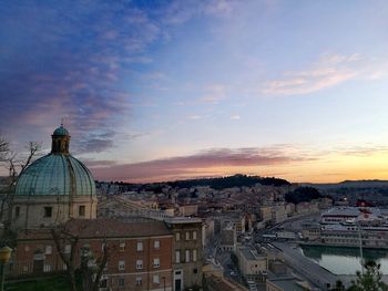 Aerial view of buildings in city against sky during sunset