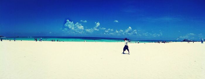 Scenic view of beach against blue sky